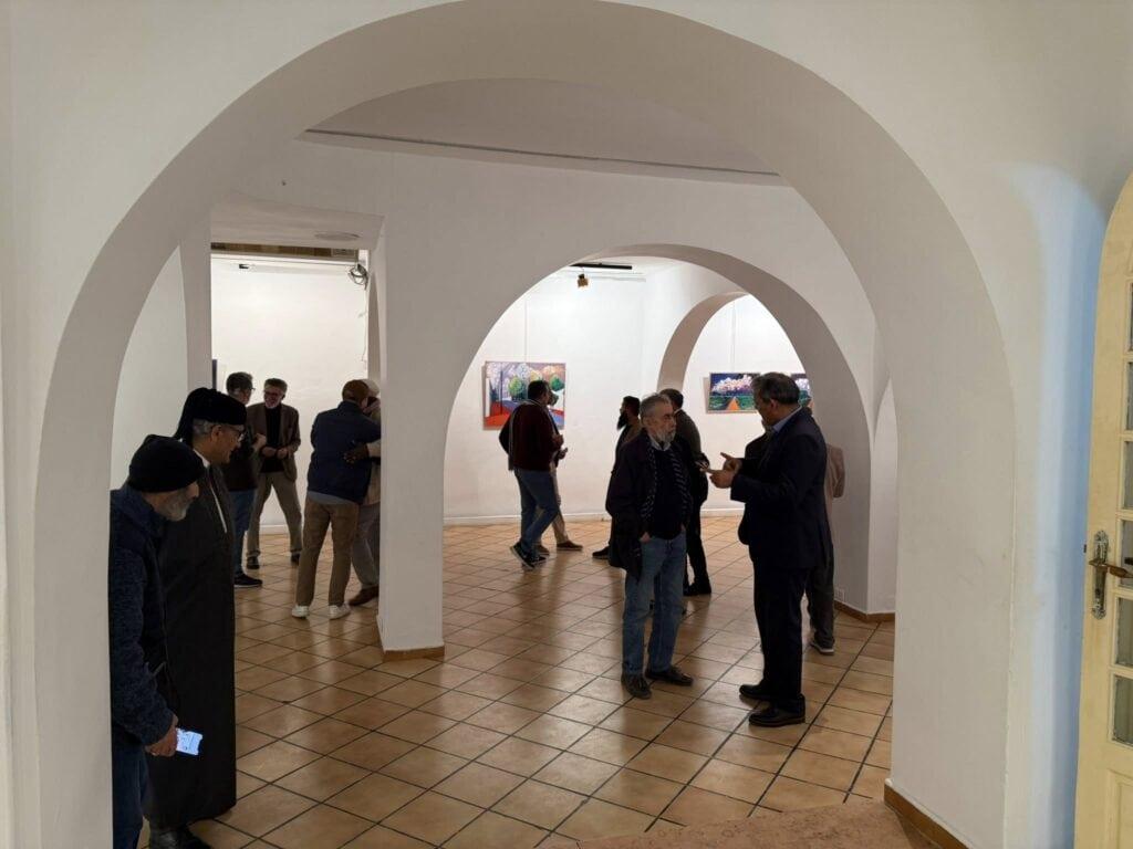 لوحة فنية مع جمهور في معرض أفانين للفنون الجميلة في حوار وتفاعل فني.